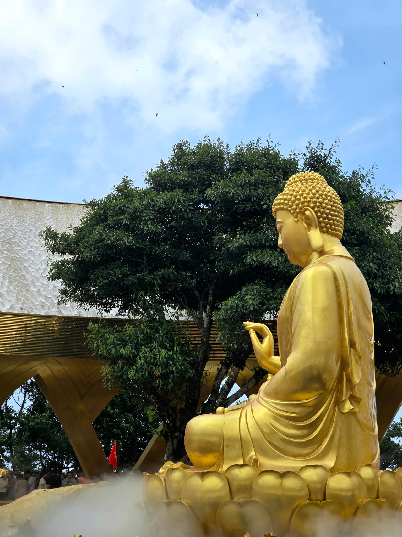 Golden Buddha statue in a peaceful garden.